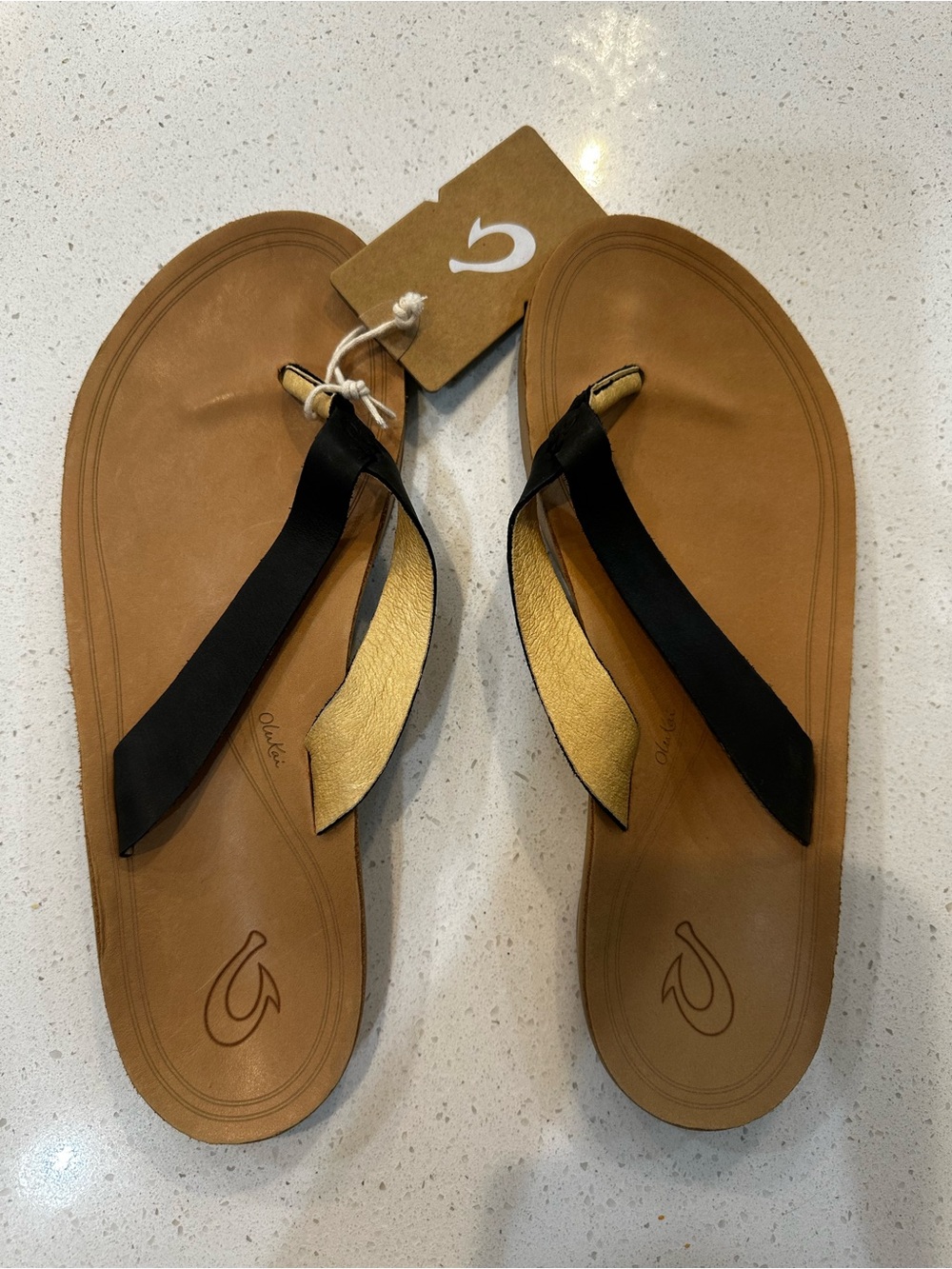 OluKai Nonohe Black and Golden Sand Leather Sandals